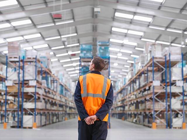 Employee standing in a large warehouse