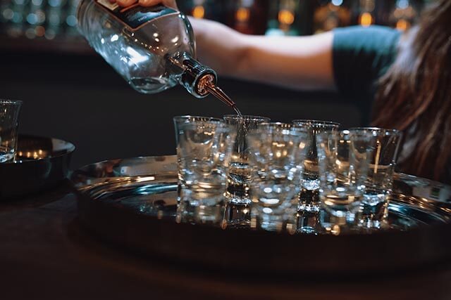Bar tender pouring a tray of shots in a nightclub