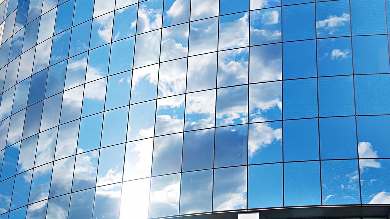 External of a building with blue sky reflected in the glass windows