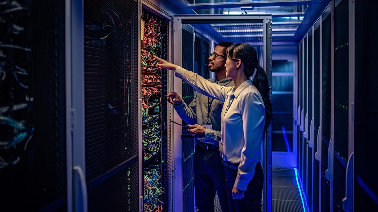 Data tachnicians looking at a computer server
