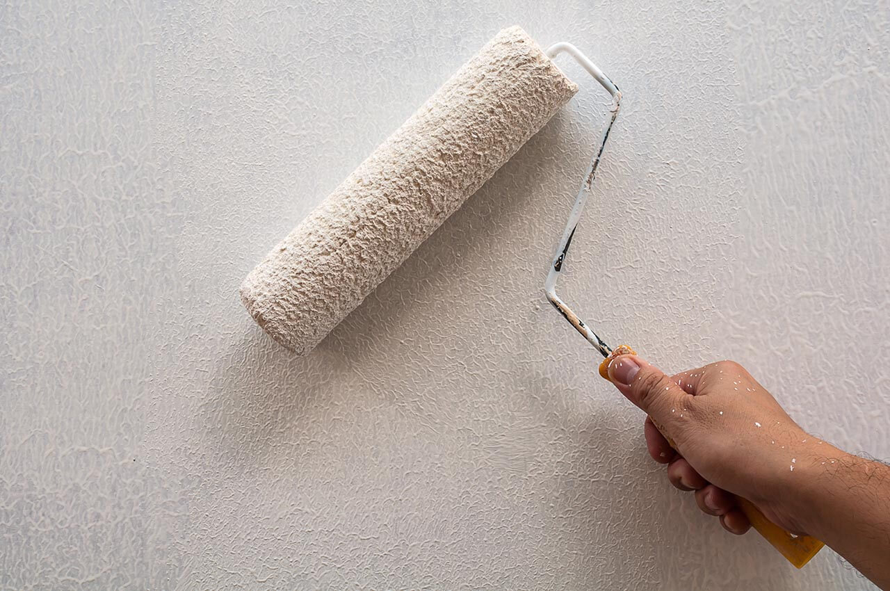 Paint roller applying paint to a wall