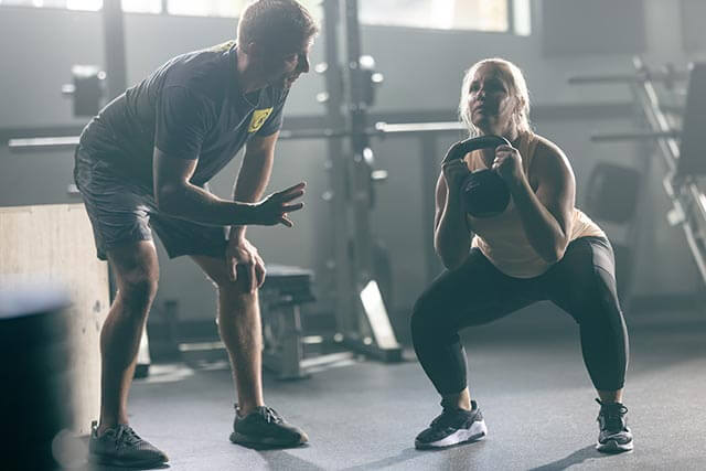 Personal trainer training a client in a gym