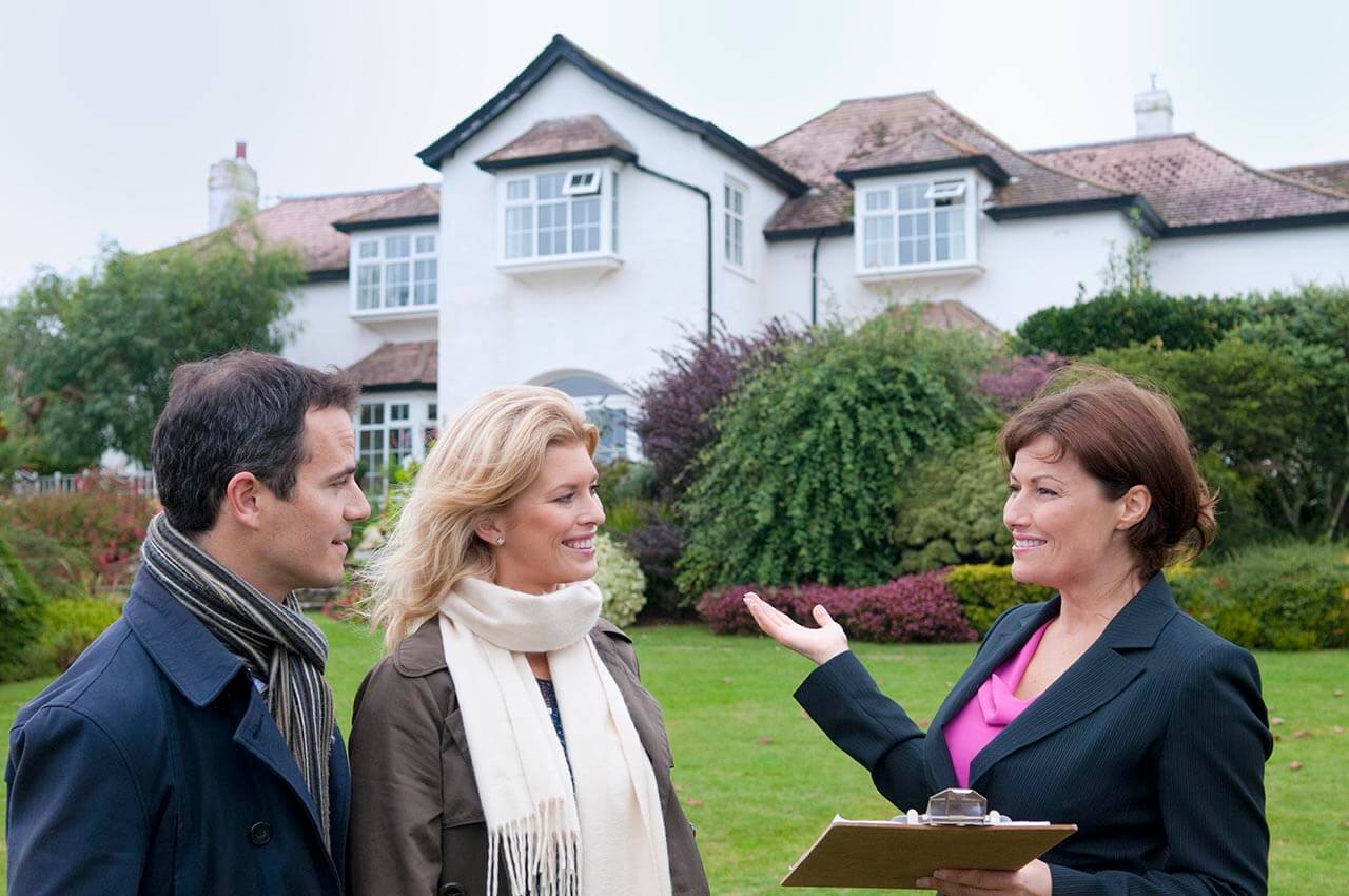 Estate agent showing clients outside a house